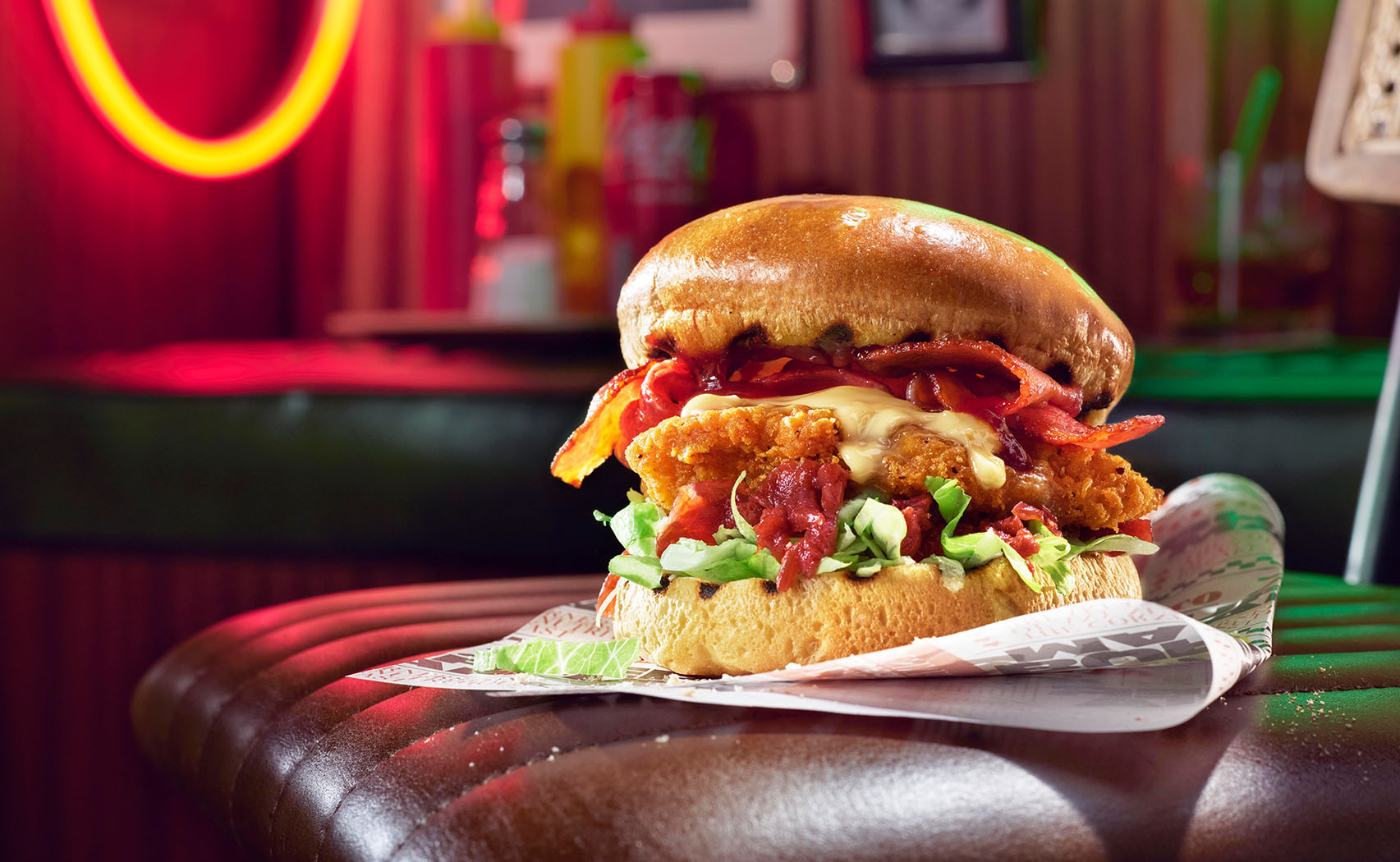 a photo by STUDIO_M of a well lit and styled burger sitting in the surrounding of a 50's American diner