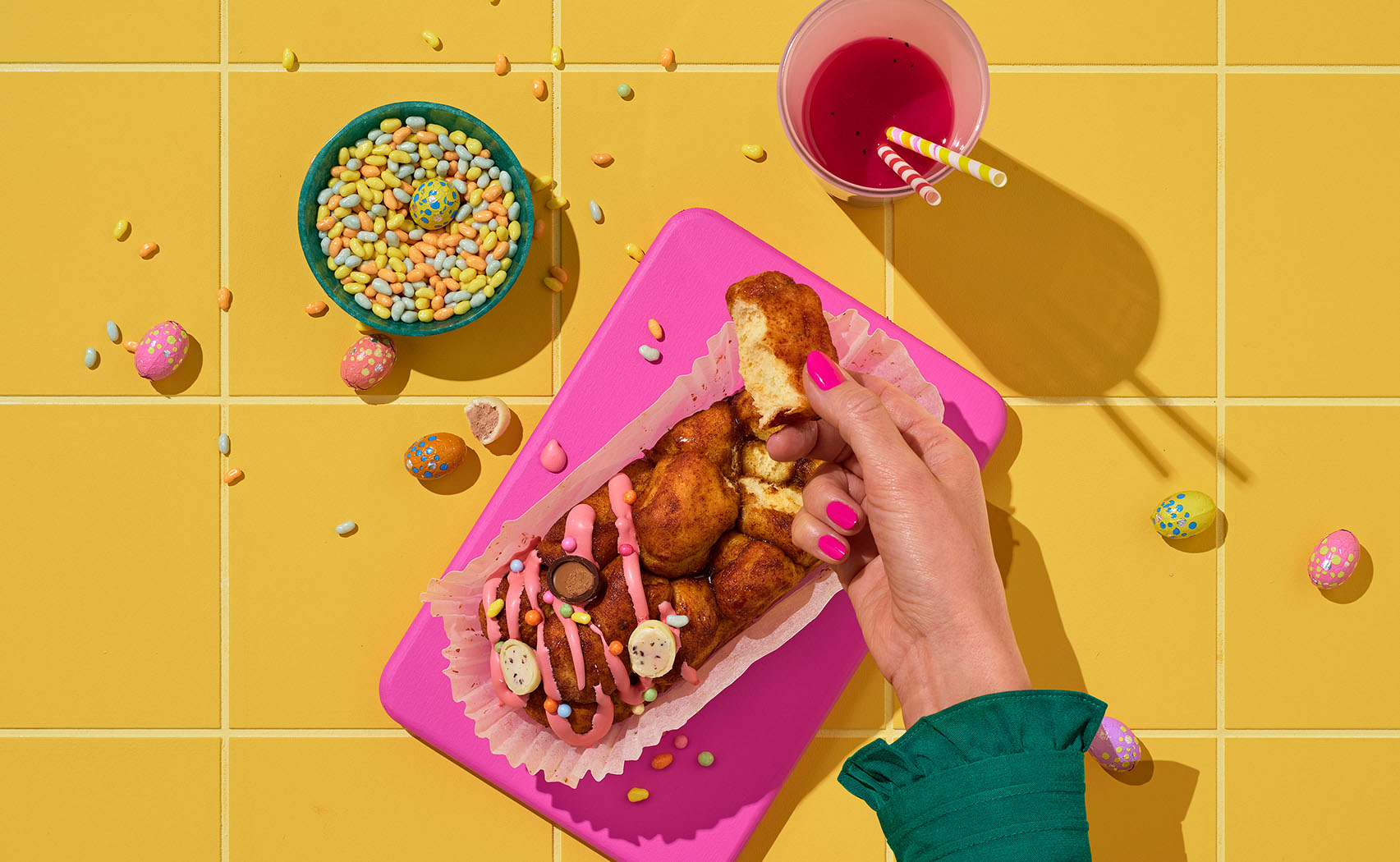 colorful image of a hand picking up a piece of sweet bread from the table, show top down