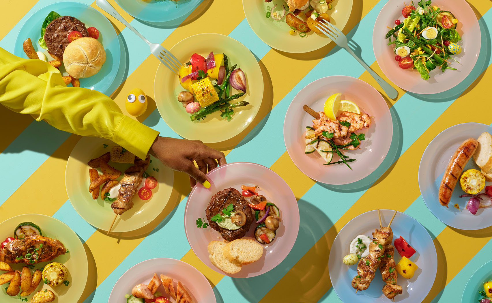 colorful and graphic image of a hand picking up a plate from several lines of plates on the table, show top down