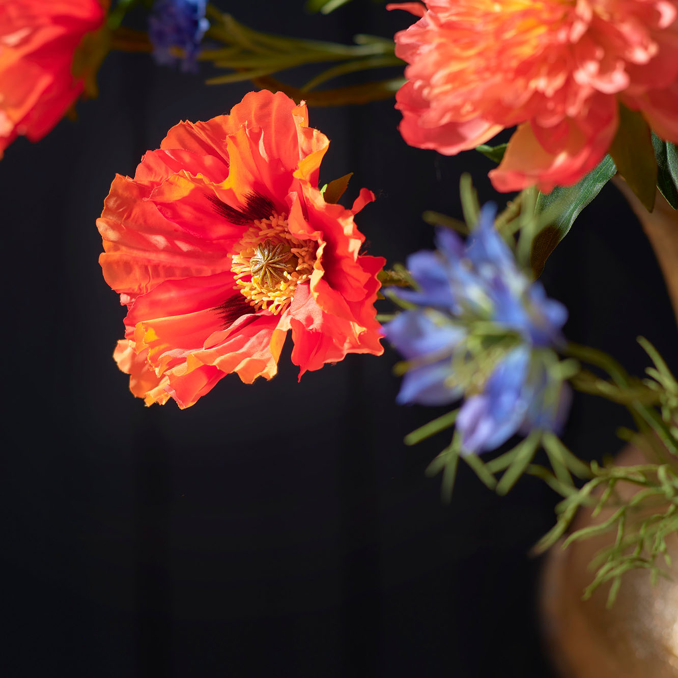 Close-up van delicate kleurrijke zijden bloemen gemixt boeket, gefotografeerd tegen een donkergrijze achtergrond. De bloemen zijn gedetailleerd weergegeven, waardoor hun textuur en natuurlijke uitstraling goed tot hun recht komen.